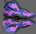 Purple and pink camouflage sneakers with black accents on a beige surface